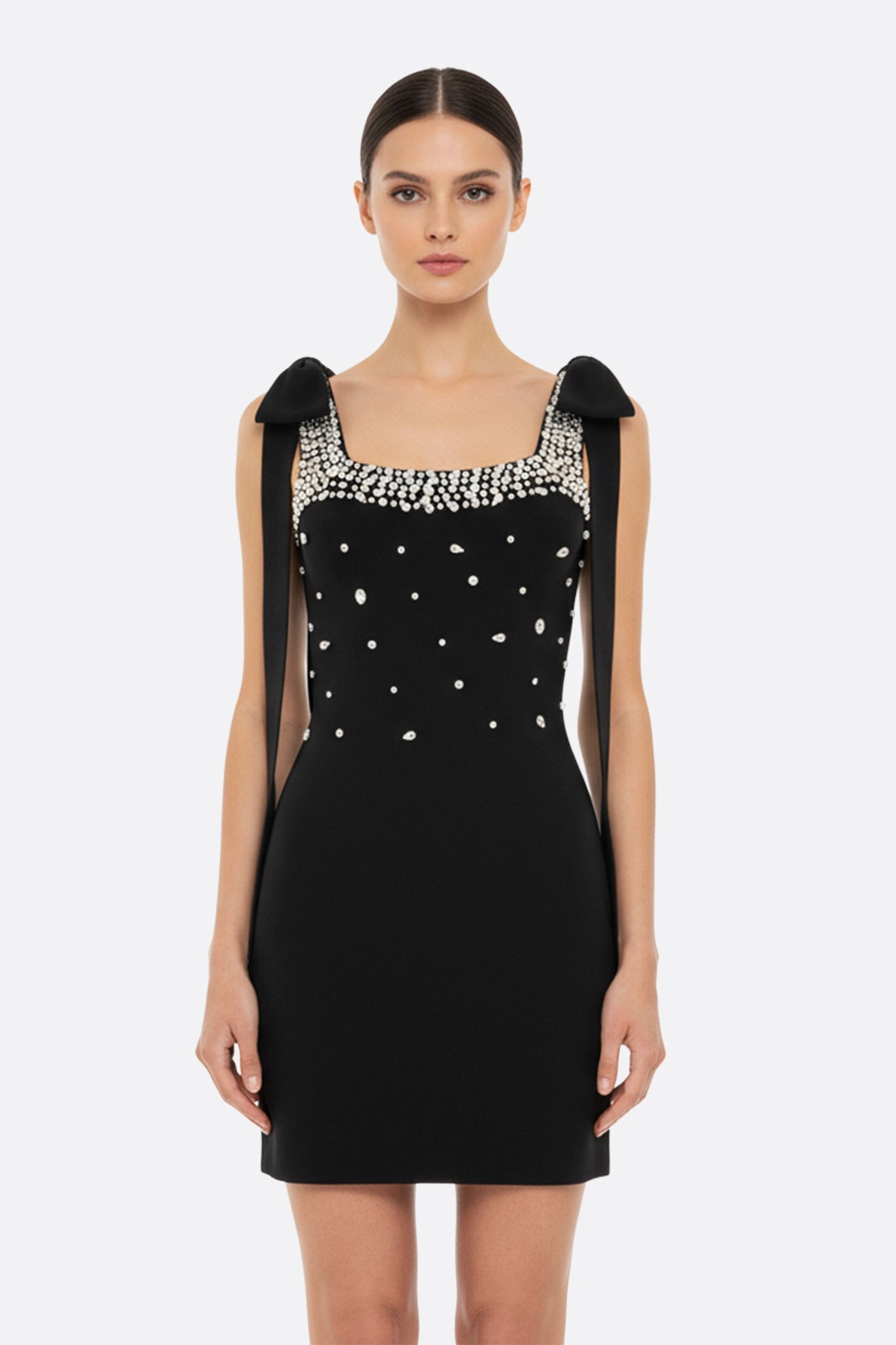 Vestido corto negro adornado con perlas y lazos en los hombros
